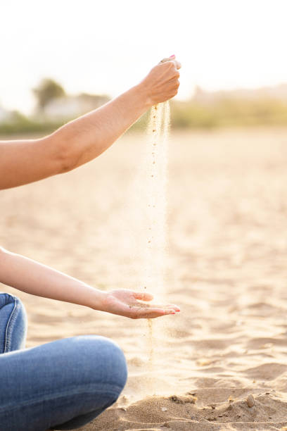 istock Unrecognizable woman playing with the sand in the beach. 1326448382