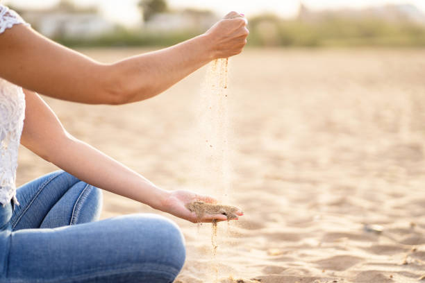 istock Unrecognizable woman playing with the sand in the beach. 1326448391