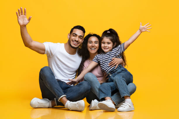 istock Cheerful Arab Family Having Fun While Sitting On Floor Over Yellow Background 1326448536