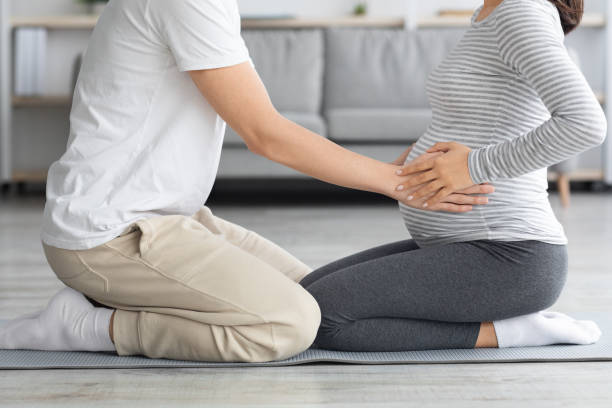 istock Unrecognizable man touching his pregnant wife big belly while exercsising 1326449235