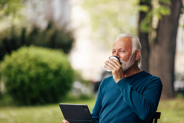 istock Mature man, relaxing in the park, while taking a break from work. 1326449439