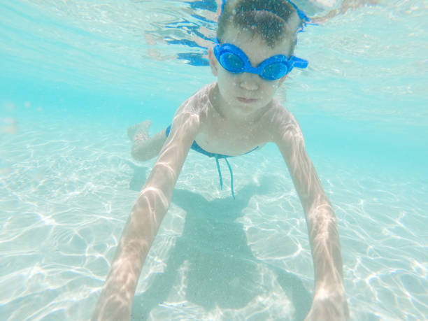 istock Happy kid enjoying while diving in sea 1326449444