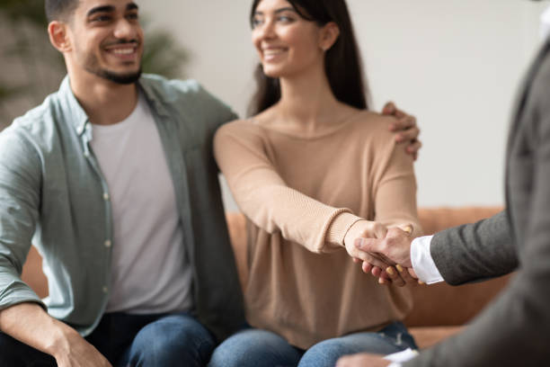 istock Happy couple shaking hands with therapist at office 1326450212