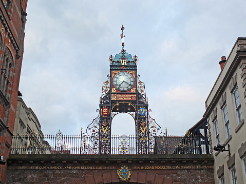 historic bridge over eastgate street with victorian clock tower and surrounding buildings in chester. cheshire