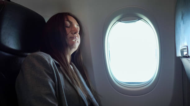 istock Brunette woman sleeping while sitting in an uncomfortable position on the plane 1326456606