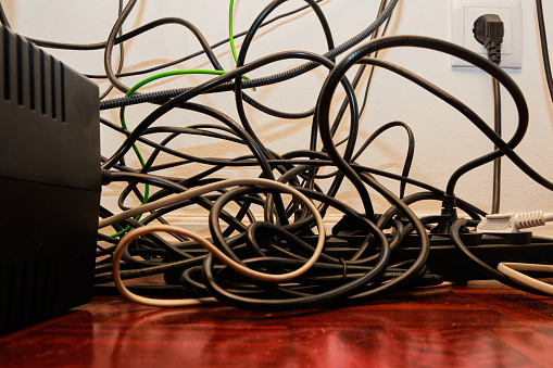 Disorganized Cables on the Floor of a Computer Desk