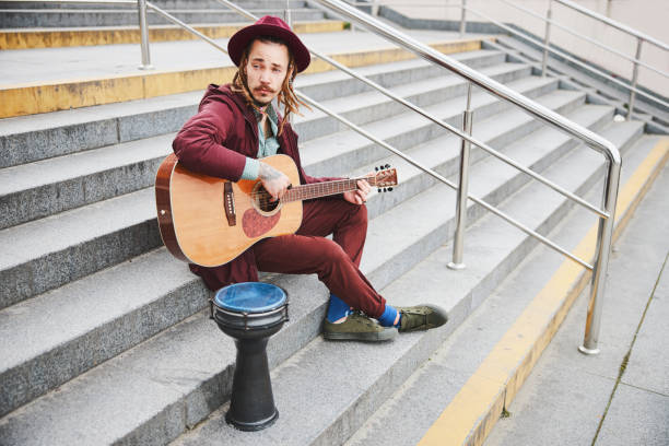 istock Kind hippie sitting on stairs with guitar 1326459769