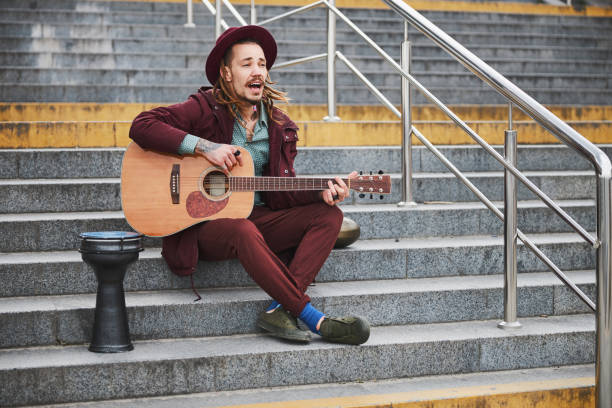 istock Joyful man with dreadlocks playing music outdoors 1326459812