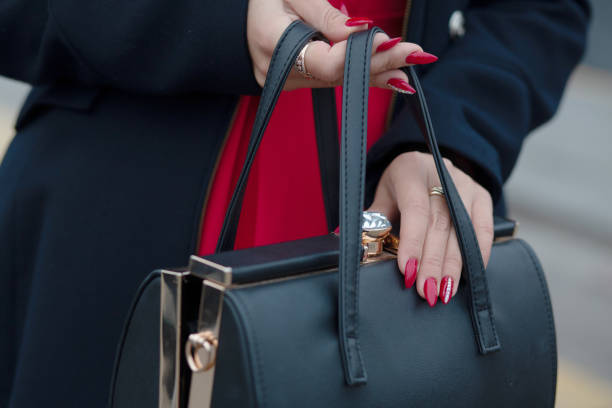 Woman wearing stylish blue coat opening black leather purse. Space for text