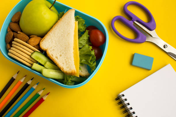 istock School lunch in the box, pencils and notebook on the yellow background 1326461059