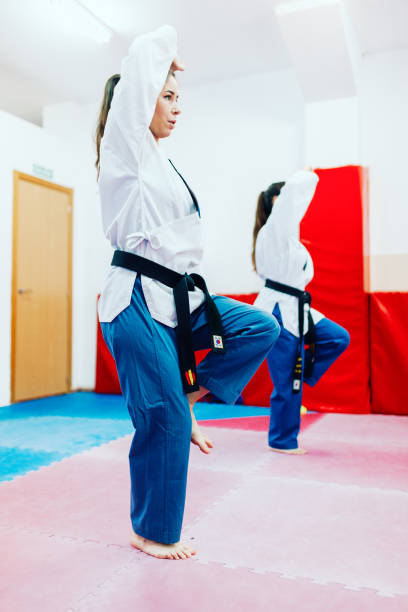 istock Two young women practice taekwondo in a training center 1326461423