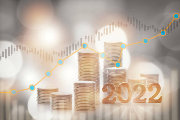 2022 with stack of coins and growth graph on bokeh background