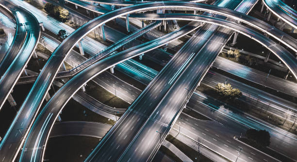 高いマルチレベルトラフィックジャンクションの夜間長時間露光照明。中国、成都におけるバックライト道路と現在の新しいインフラの近代的な発展。空中ドローンの視点。 - aerial view shanghai technology multiple lane highway ストックフォトと画像