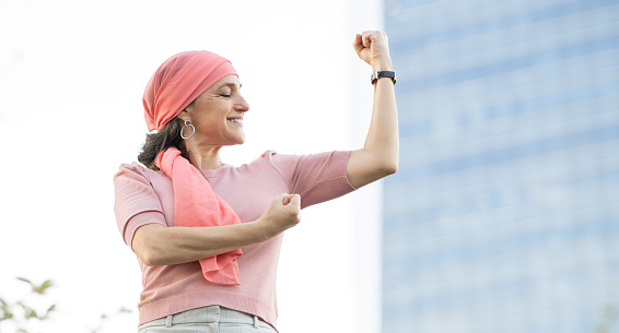 mujer con pañuelo rosado en la cabeza que lucha contra el cáncer photo