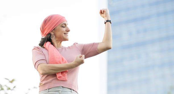 mujer con pañuelo rosado en la cabeza que lucha contra el cáncer - breast cancer fotografías e imágenes de stock