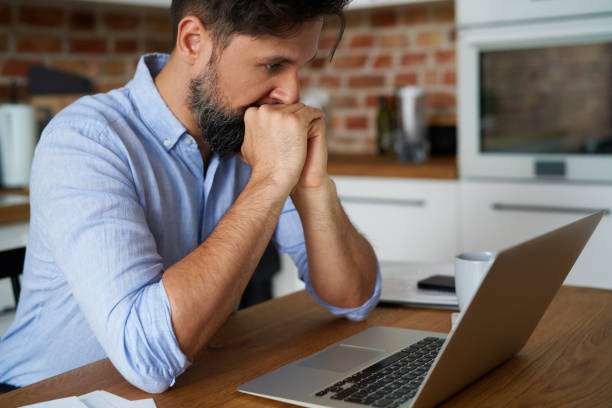 istock Stressed man sitting in front of a laptop at home 1326469340
