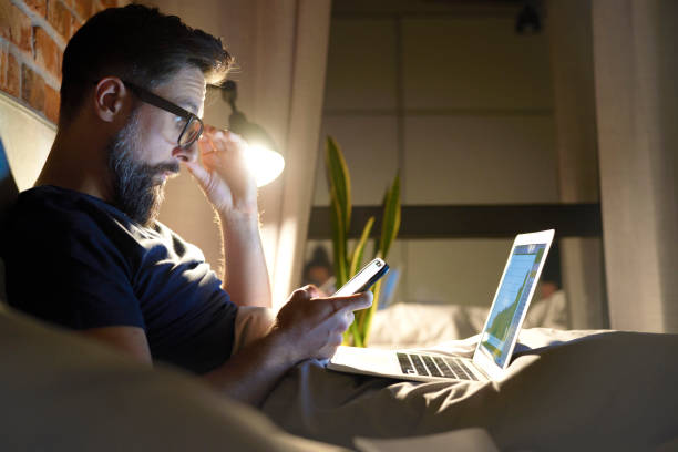 istock Side view of man with glasses working in bed at night 1326471229