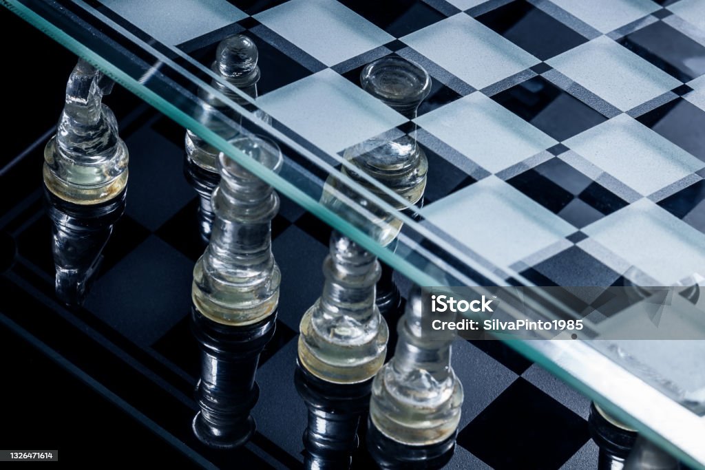 Glass chessboard with white and black pieces. Achievement Stock Photo