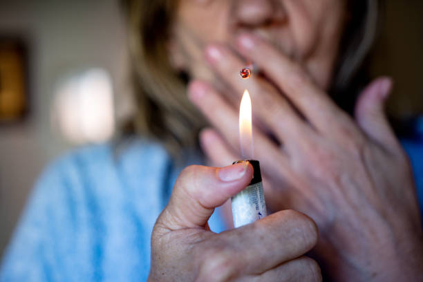istock Smoker with lighter cigarette smoking indoors 1326472600