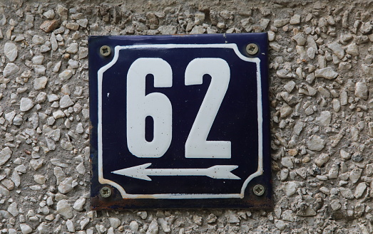 Vintage grunge square metal rusty plate of number of street address with number. Close up, brand.