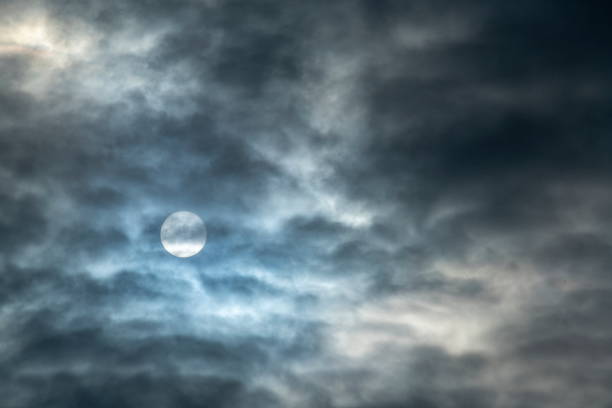 istock The white disk of the sun shines through thin cloud cover 1326476472
