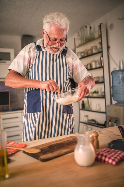 istock Senior man  making pancakes in the kitchen 1326477988