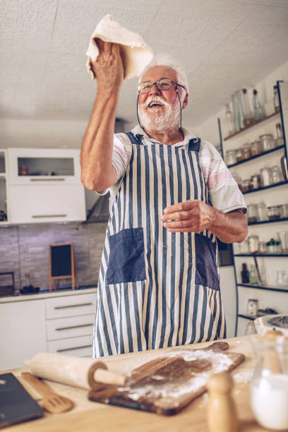 istock Senior man  making pancakes in the kitchen 1326478000
