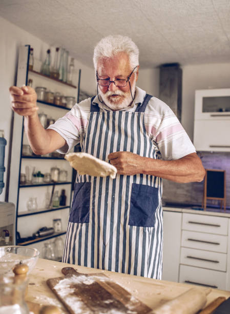 istock Senior man  making pancakes in the kitchen 1326478051