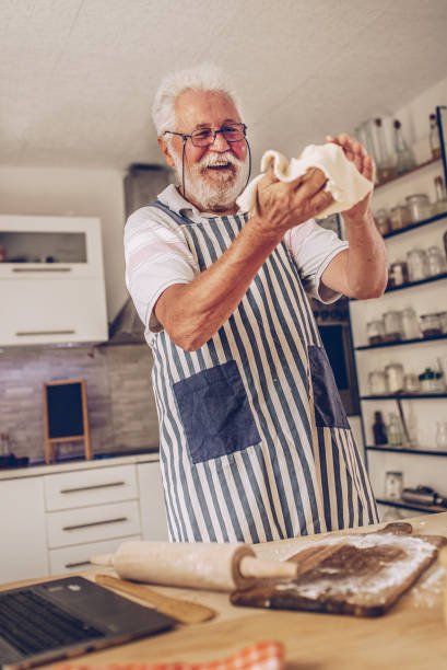 istock Senior man  making pancakes in the kitchen 1326478073