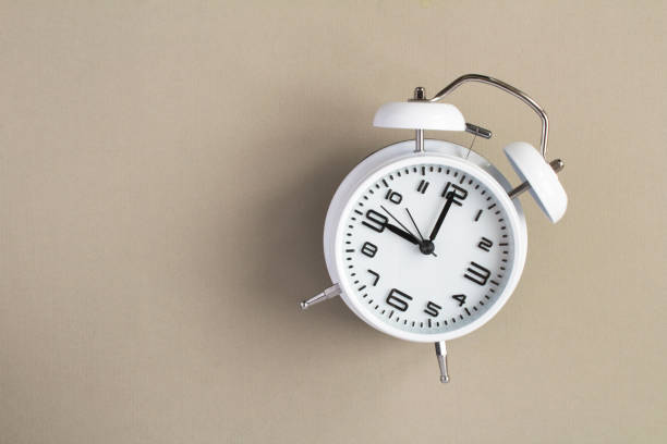 istock Top view of white alarm clock on the gray background 1326478087