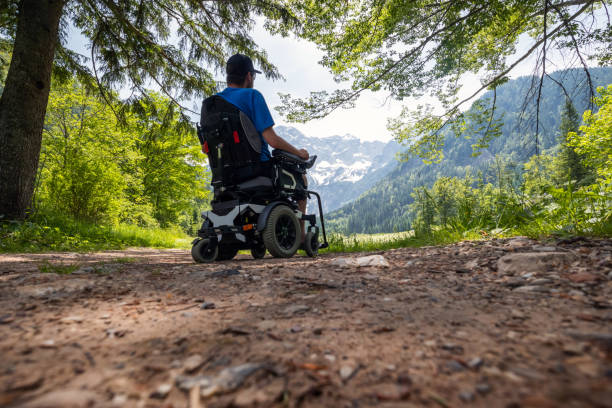 hombre en silla de ruedas en la naturaleza - cuadriplégico fotografías e imágenes de stock