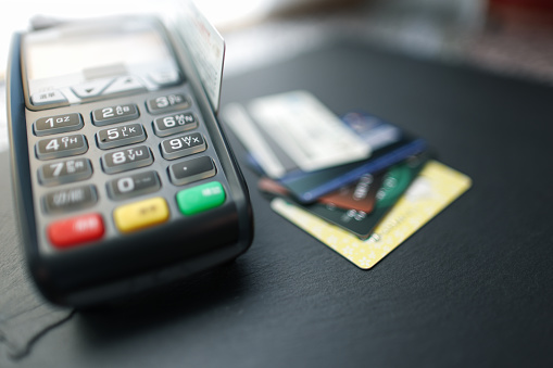 A silver credit card and shopping cart are on the table with blurred background. online shopping and credit card payment concept. close-up image