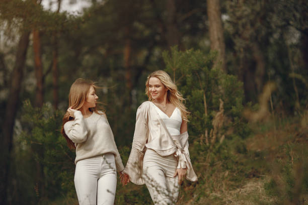 Elegant mother with daughter. Family walks in a forest.