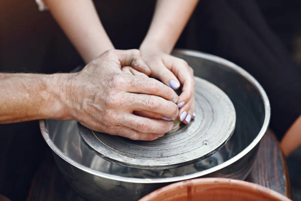 istock People making a vaze from a clay on a pottery's machine 1326482453