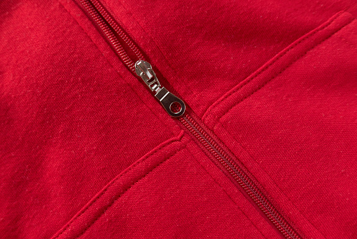 Close detail of kids red hoodie sweatshirt with zip fastener and pocket.