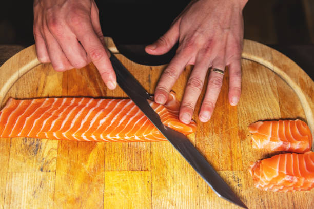 istock Chef cutting salmon fillet for sushi 1326483584