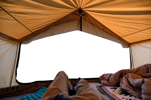Traveler man relaxing inside of yellow tent and empty scene entrance in vacation. Camping and leisure activity concept