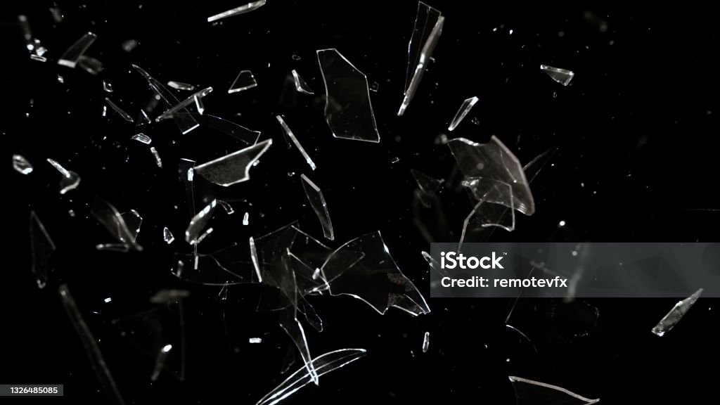 Studio Full-Frame Wide Plate Shot of Real Window Glass Pane Shattering and Breaking on Black Background Studio full-frame wide plate shot of window glass pane shattering and breaking on black background. Real smash explosion at high speed as action concept template and overlay element. Shattered Glass Stock Photo