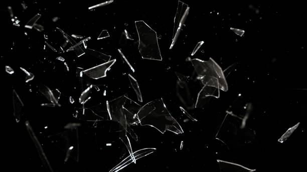 Studio Full-Frame Wide Plate Shot of Real Window Glass Pane Shattering and Breaking on Black Background Studio full-frame wide plate shot of window glass pane shattering and breaking on black background. Real smash explosion at high speed as action concept template and overlay element. slow motion photos stock pictures, royalty-free photos & images