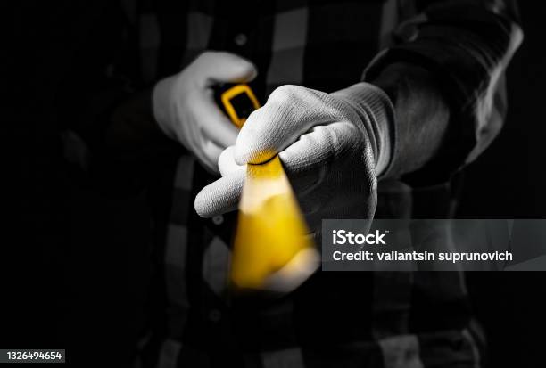 Male Hands In White Construction Gloves Holding Yellow Retractable Tape Measure Tool And Showing It Forward To Camera Closeup Stock Photo - Download Image Now