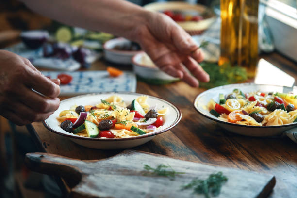istock Preparing Greek Salad with Farfalle Pasta 1326495973