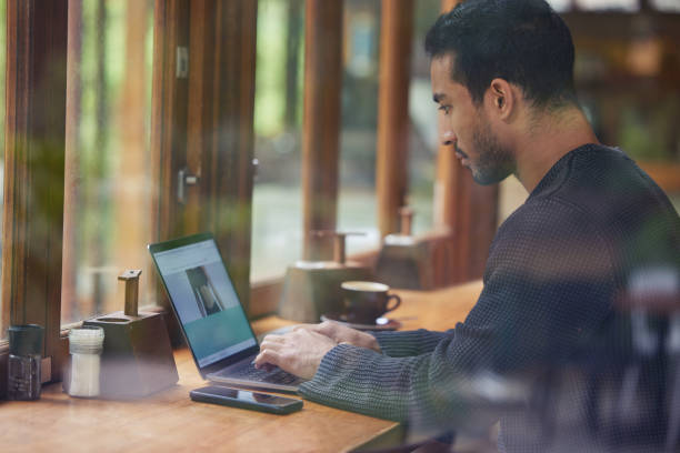 istock Shot of a man using his laptop while sitting in a cafe 1326497073