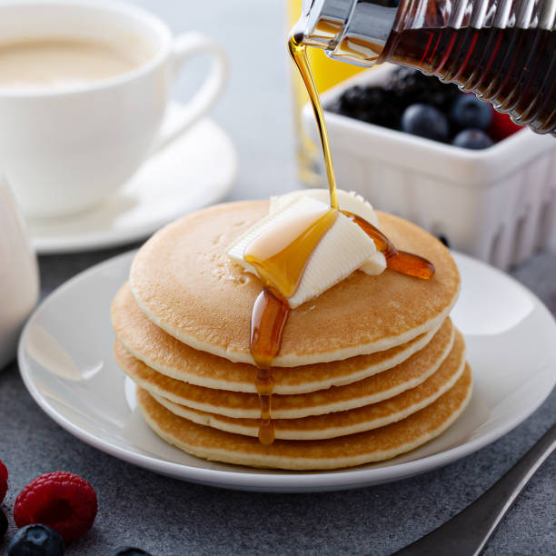 istock Stack of pancakes with butter and syrup pouring over 1326497408