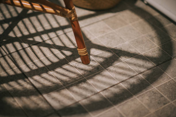 shadow of rattan chair on tile floor with high angle view