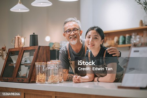 istock asian chinese senior male cafe owner and her daughters looking at camera smiling at coffee shop counter 1326498266