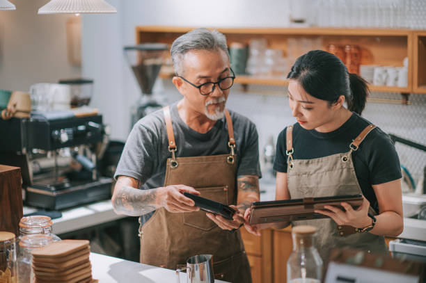 asiatische chinesische senior mann besitzer und tochter mit digitalen tablet am bar-counter-tisch - chinese ethnicity ethnic senior adult business stock-fotos und bilder