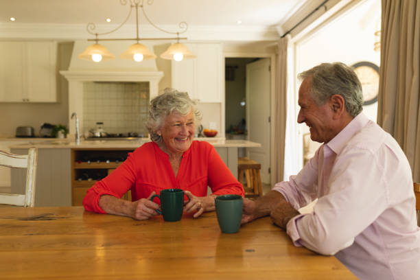 istock Senior caucasian couple sitting at table together drinking coffee in kitchen 1326503591
