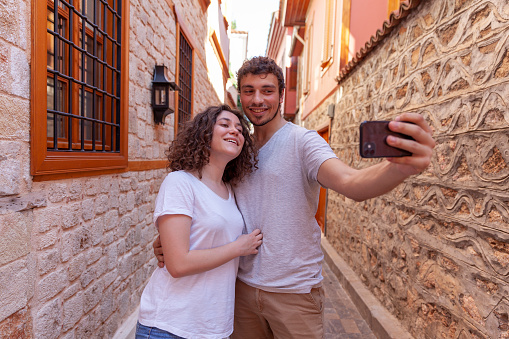 Smiling young people taking selfie inside the old town