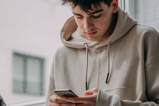 istock young man at home looking at mobile phone 1326505563