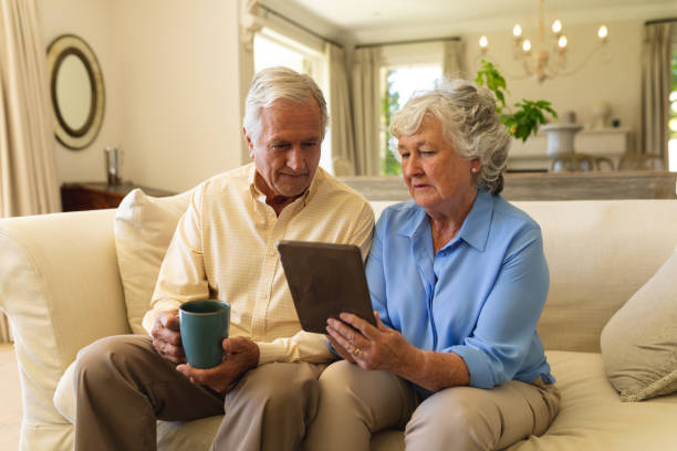 istock Senior caucasian couple sitting on sofa using tablet 1326507674